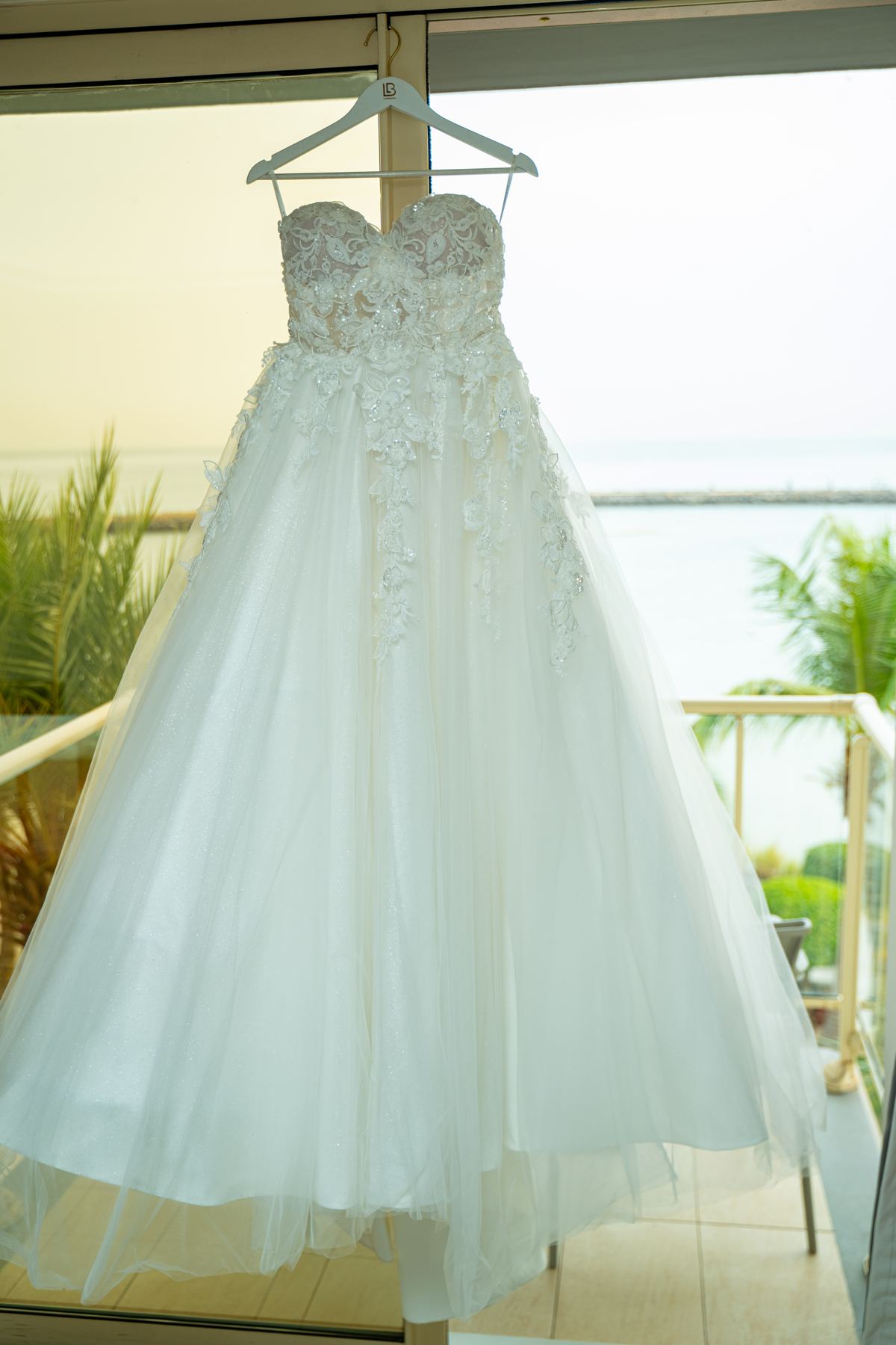 Robe de mariée suspendue sur un balcon face à la mer