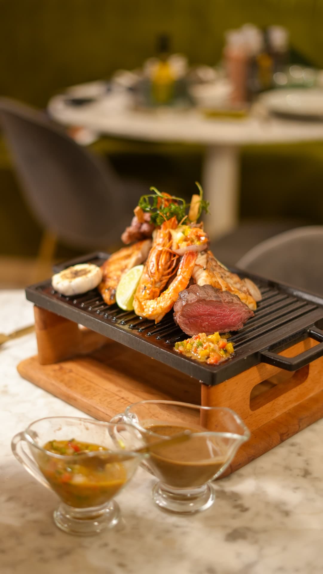 Plateau grillé de La Fourchette, gambas et viande rosée, sauces au premier plan