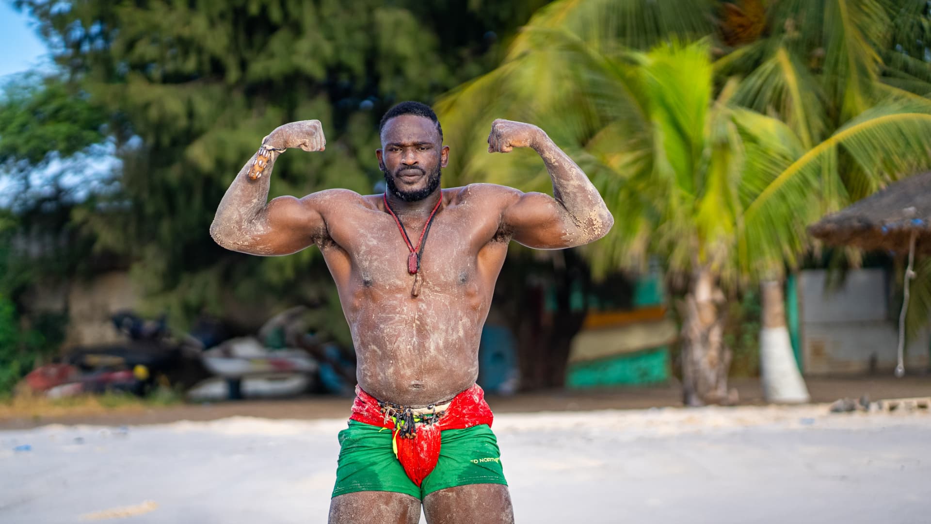 Lutteur montrant ses biceps sur la plage