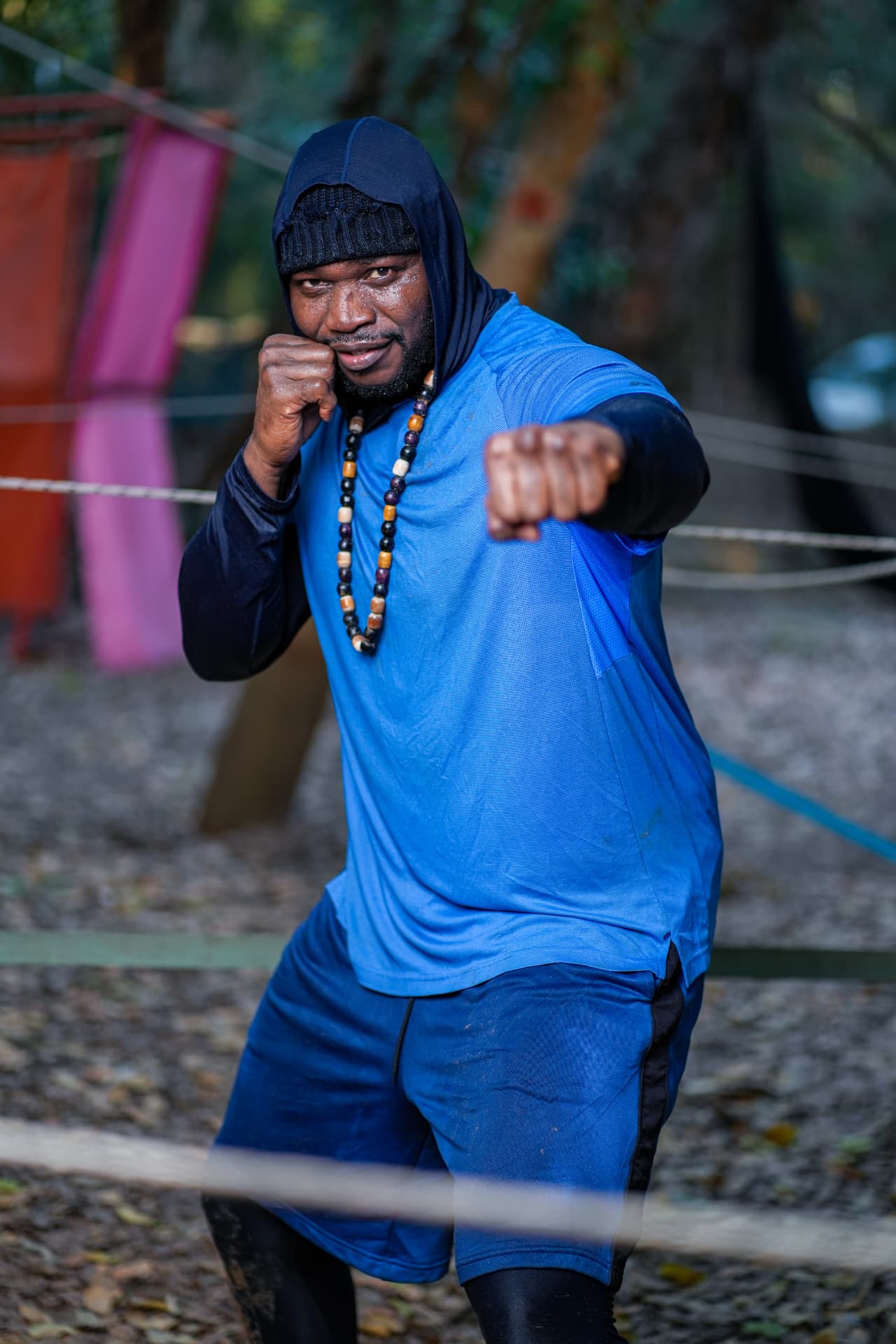 Lutteur en capuche bleue, coup de poing vers l'objectif