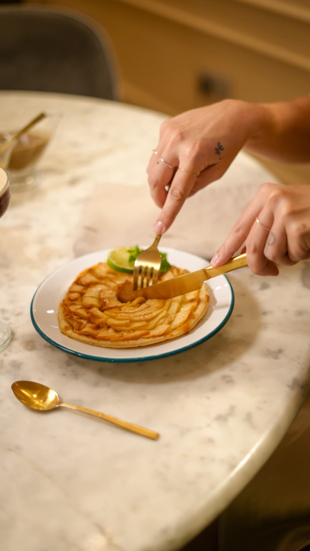 Mains découpant une tarte fine aux pommes