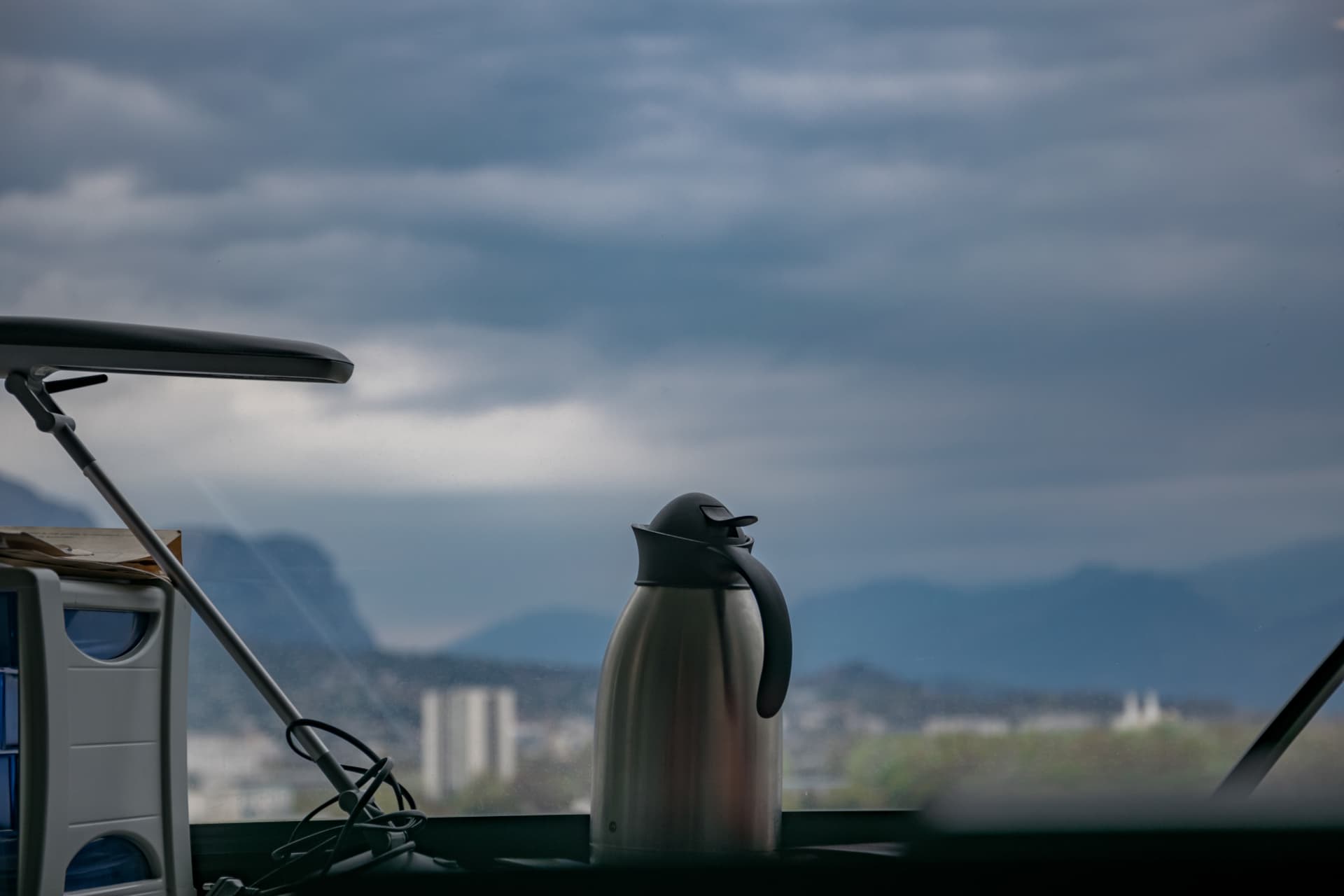 Vue depuis un bureau sur la ville et les montagnes, sous un ciel couvert