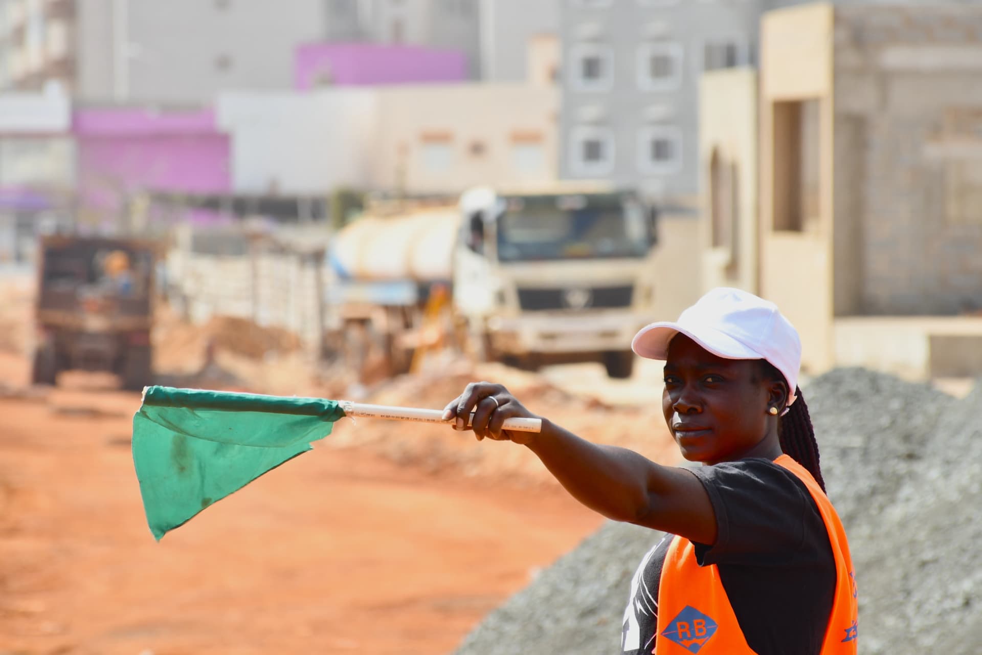 Signaleuse tenant un drapeau vert sur le chantier