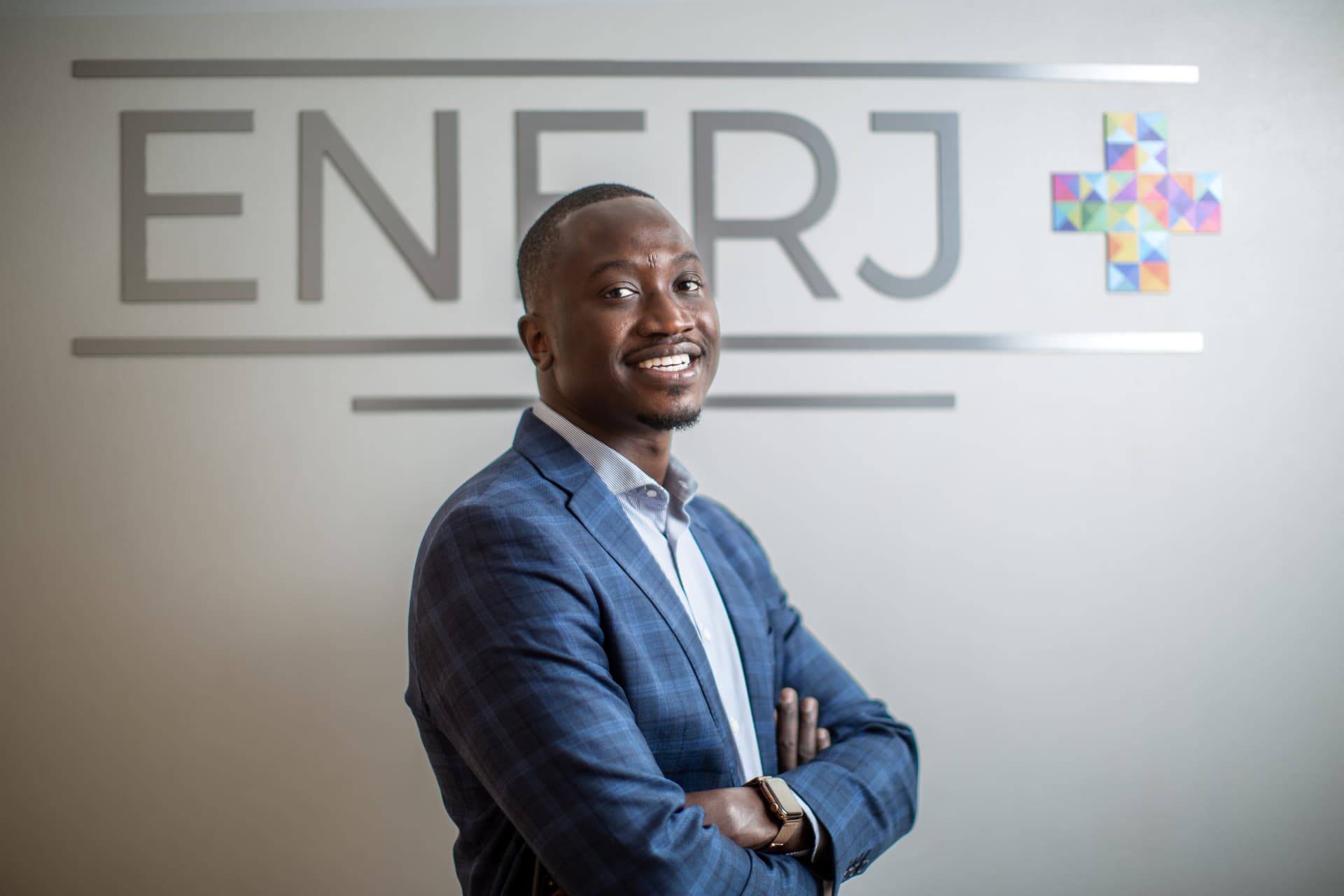 Portrait d’un collaborateur ENERJ+ devant le logo de l’entreprise