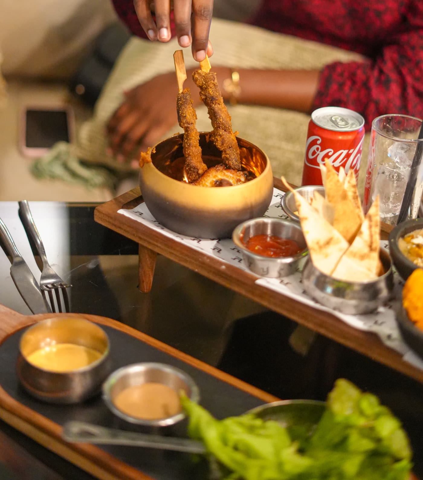 Main saisissant une brochette dans un bol doré