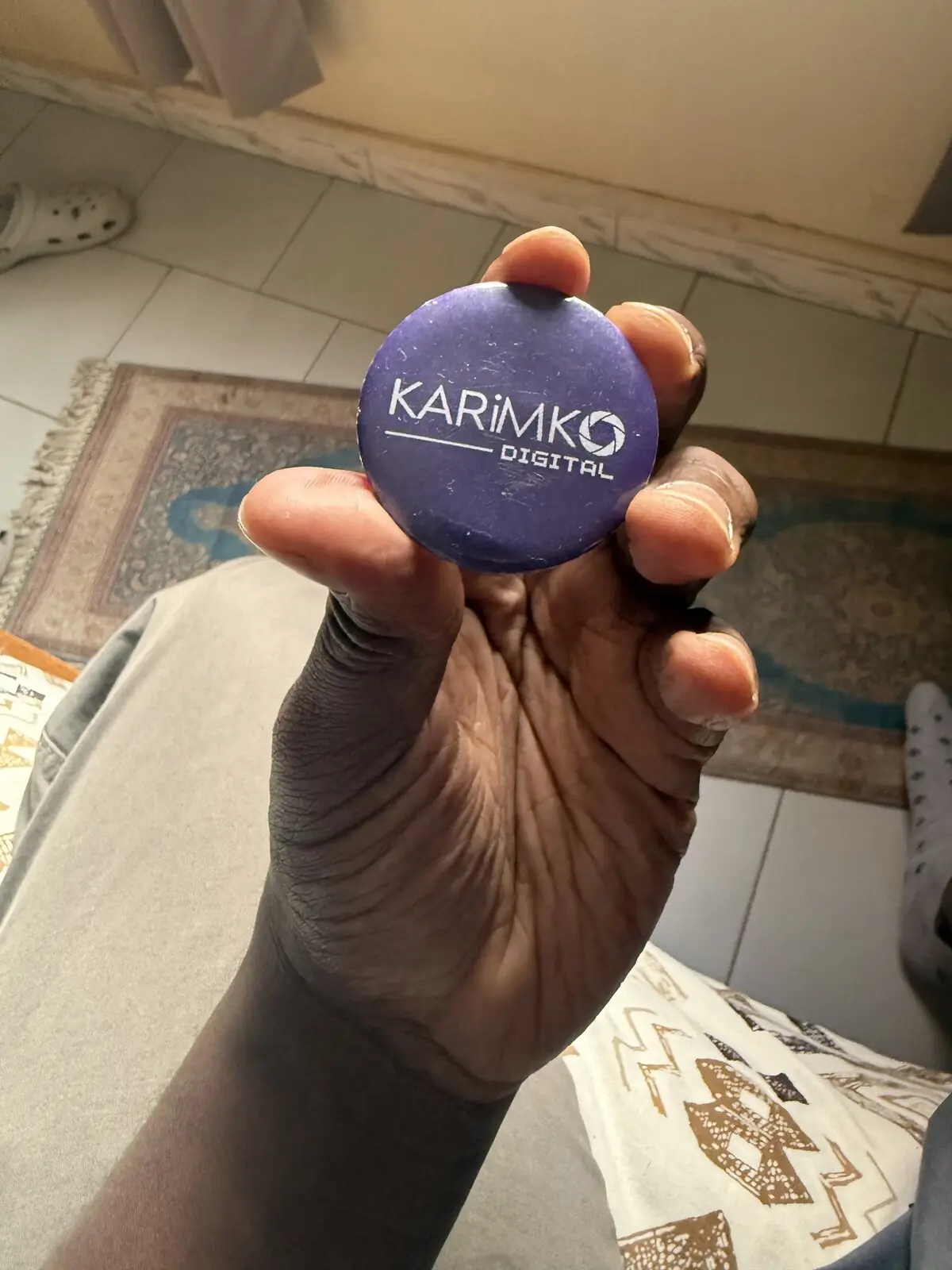 Badge KARIMKO tenu en main