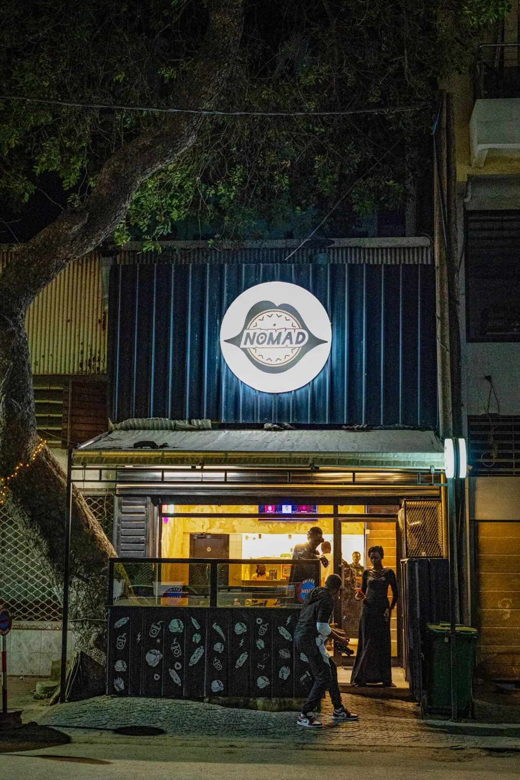 Façade éclairée du restaurant Nomad, de nuit