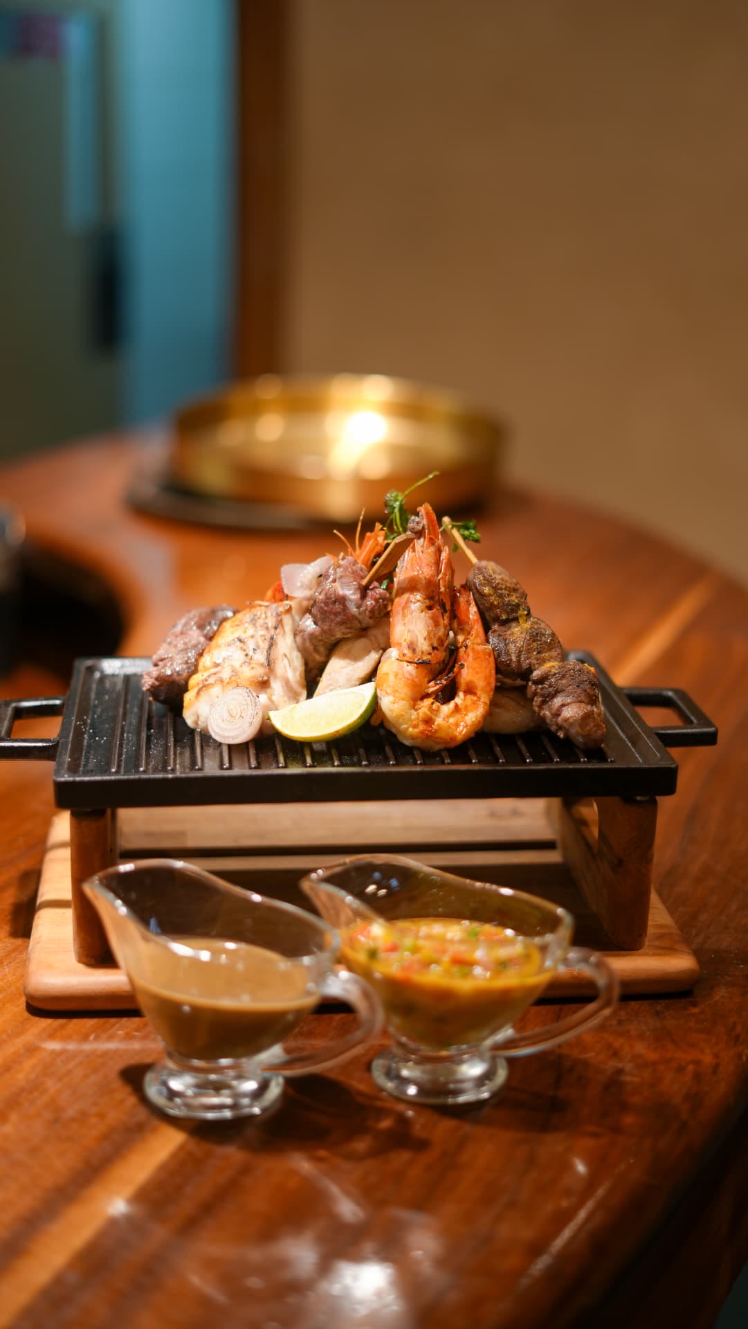 Grillade servie sur plancha au comptoir en bois, lumière chaude