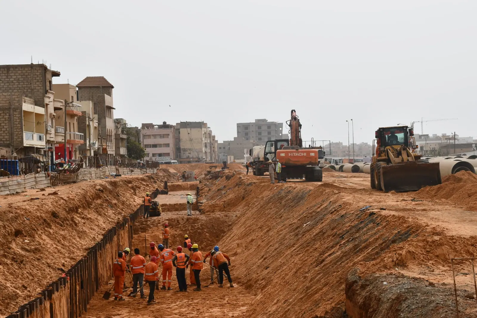 Équipes creusant une large tranchée blindée le long du corridor
