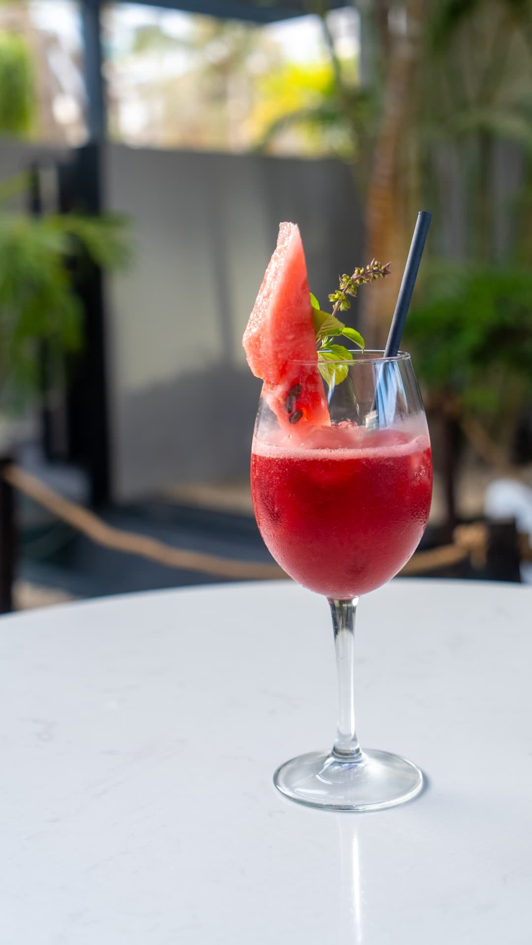 Cocktail à la pastèque et au basilic sur table blanche