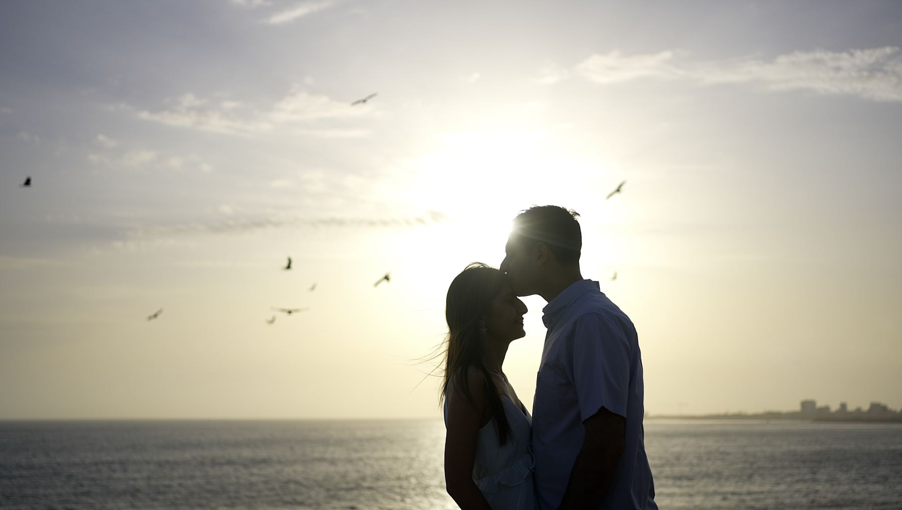 Silhouette d'un couple au coucher du soleil, face à la mer