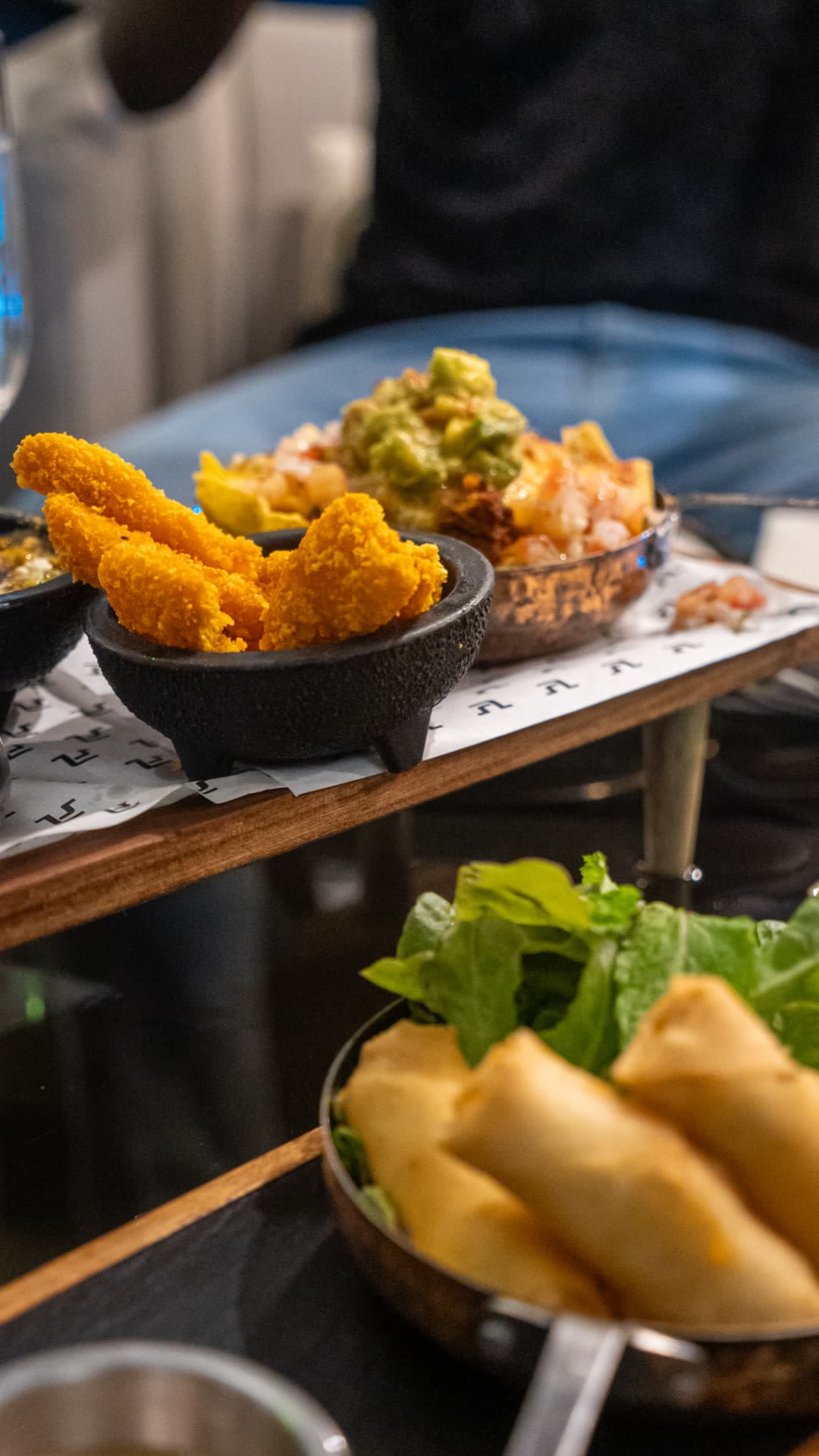 Bâtonnets panés, nachos et nems sur la table