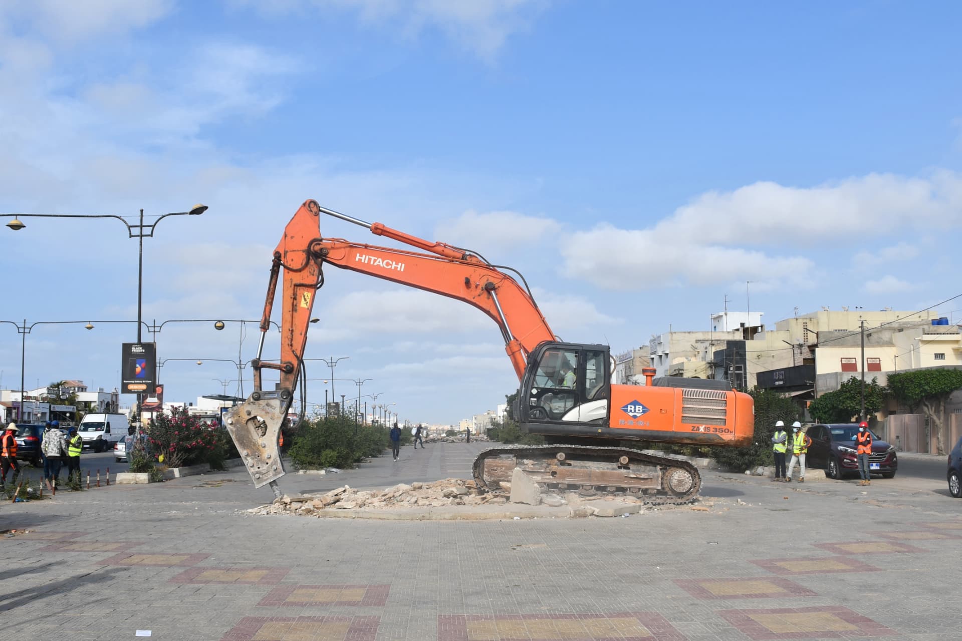 Pelleteuse avec brise-roche démolissant un terre-plein central
