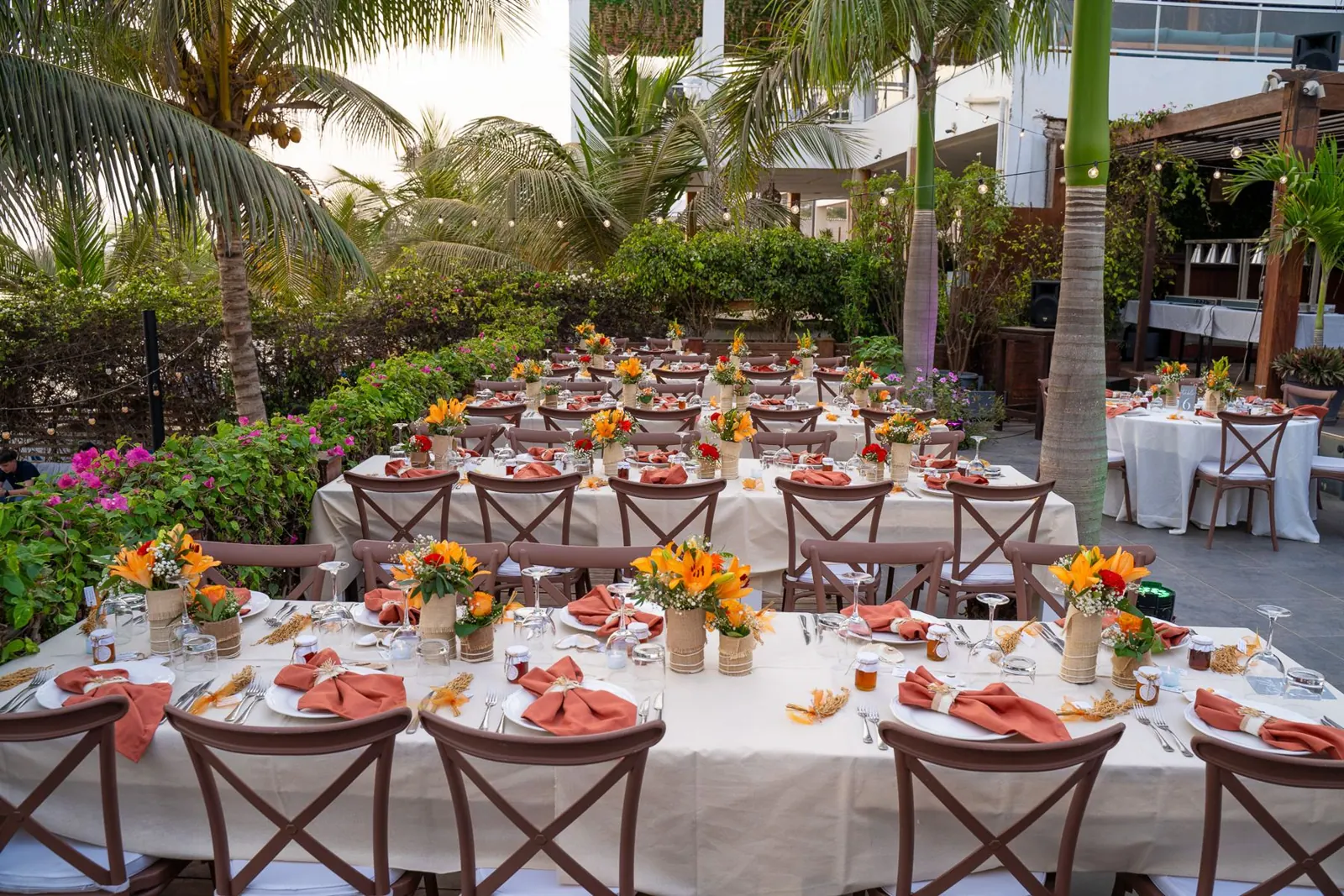 Tables dressées dans un jardin tropical, fleurs orange