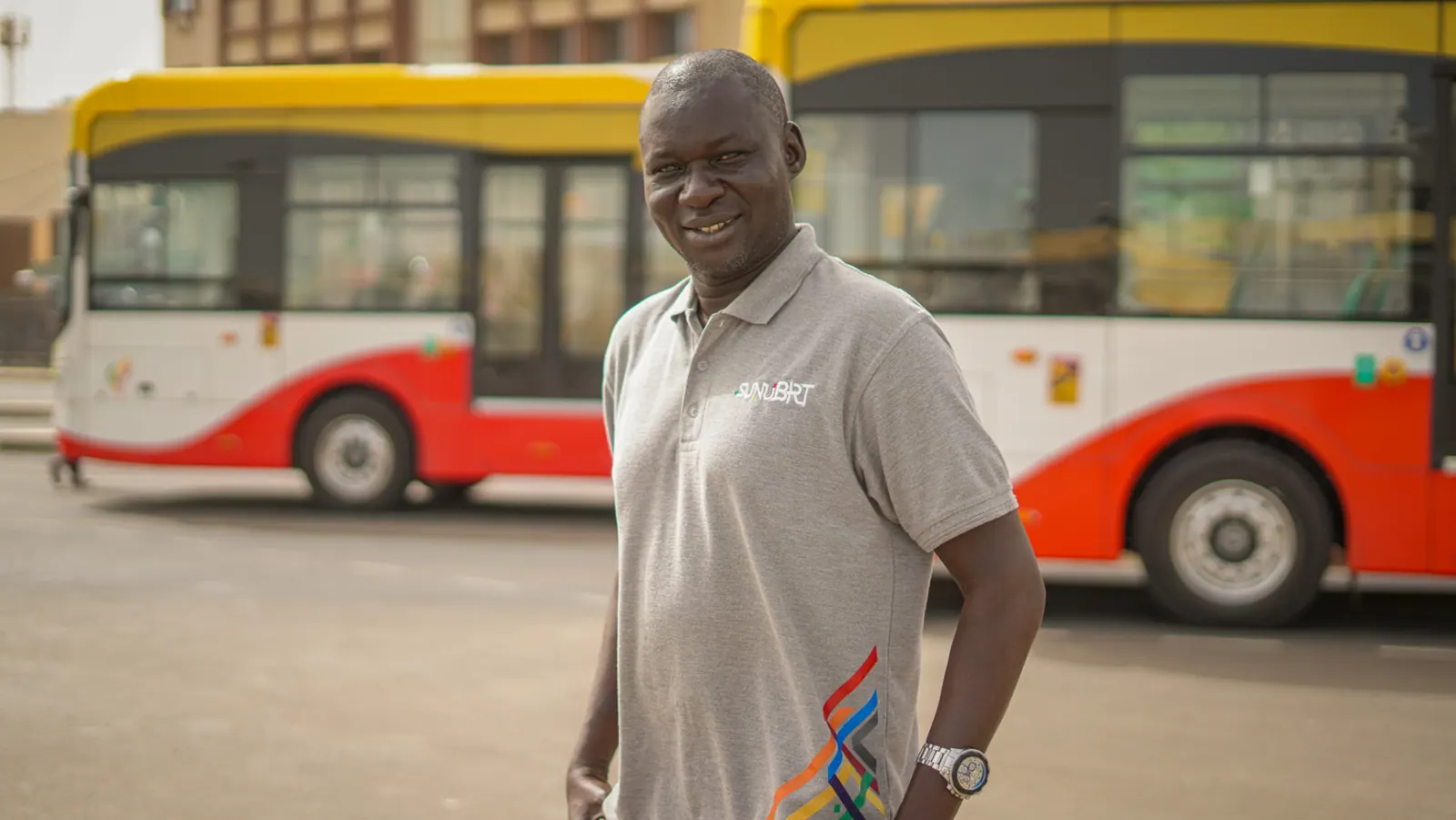 Portrait d'un agent Sunu BRT devant les bus