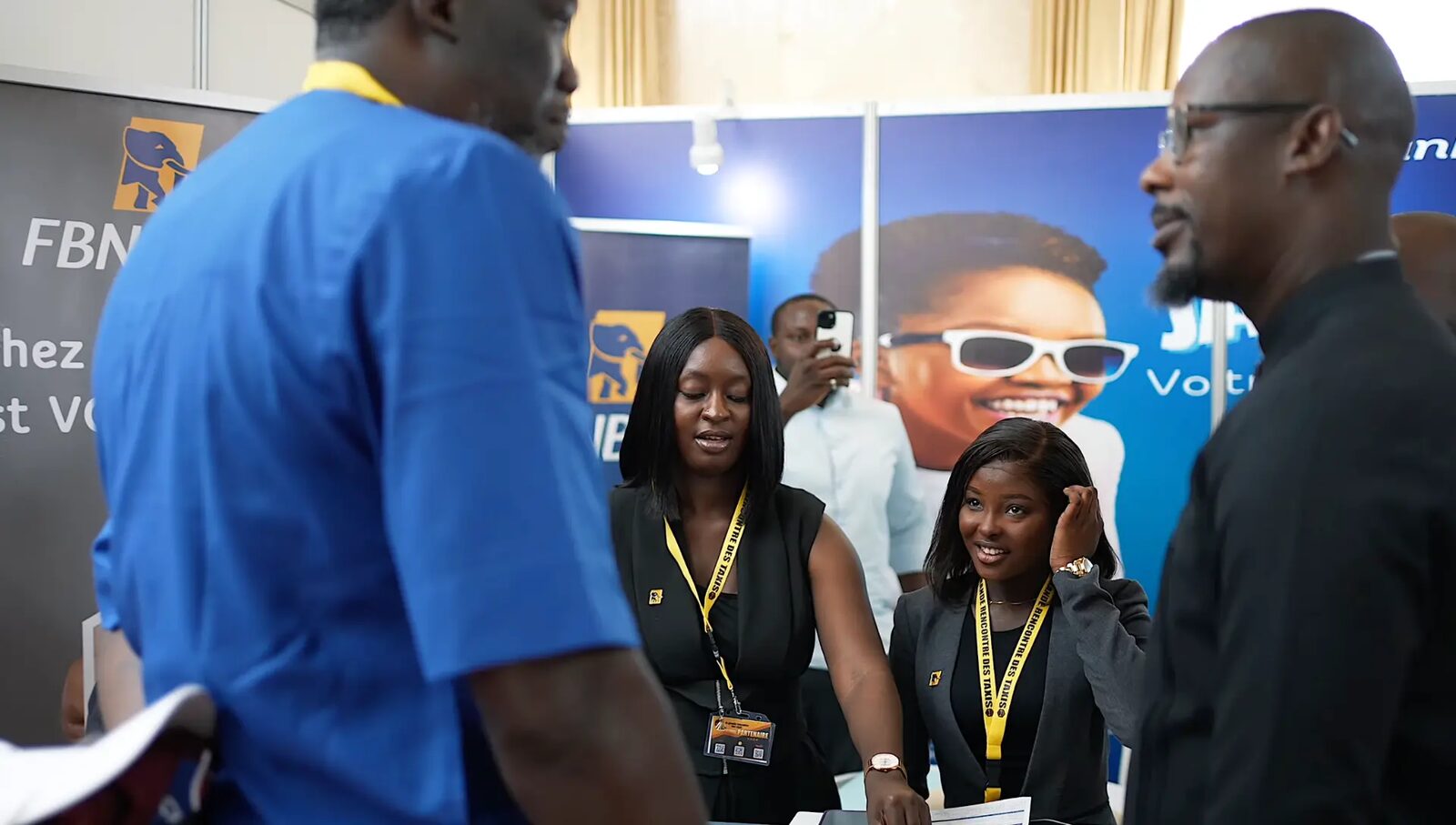 Visiteurs et équipe sur le stand d'une banque partenaire
