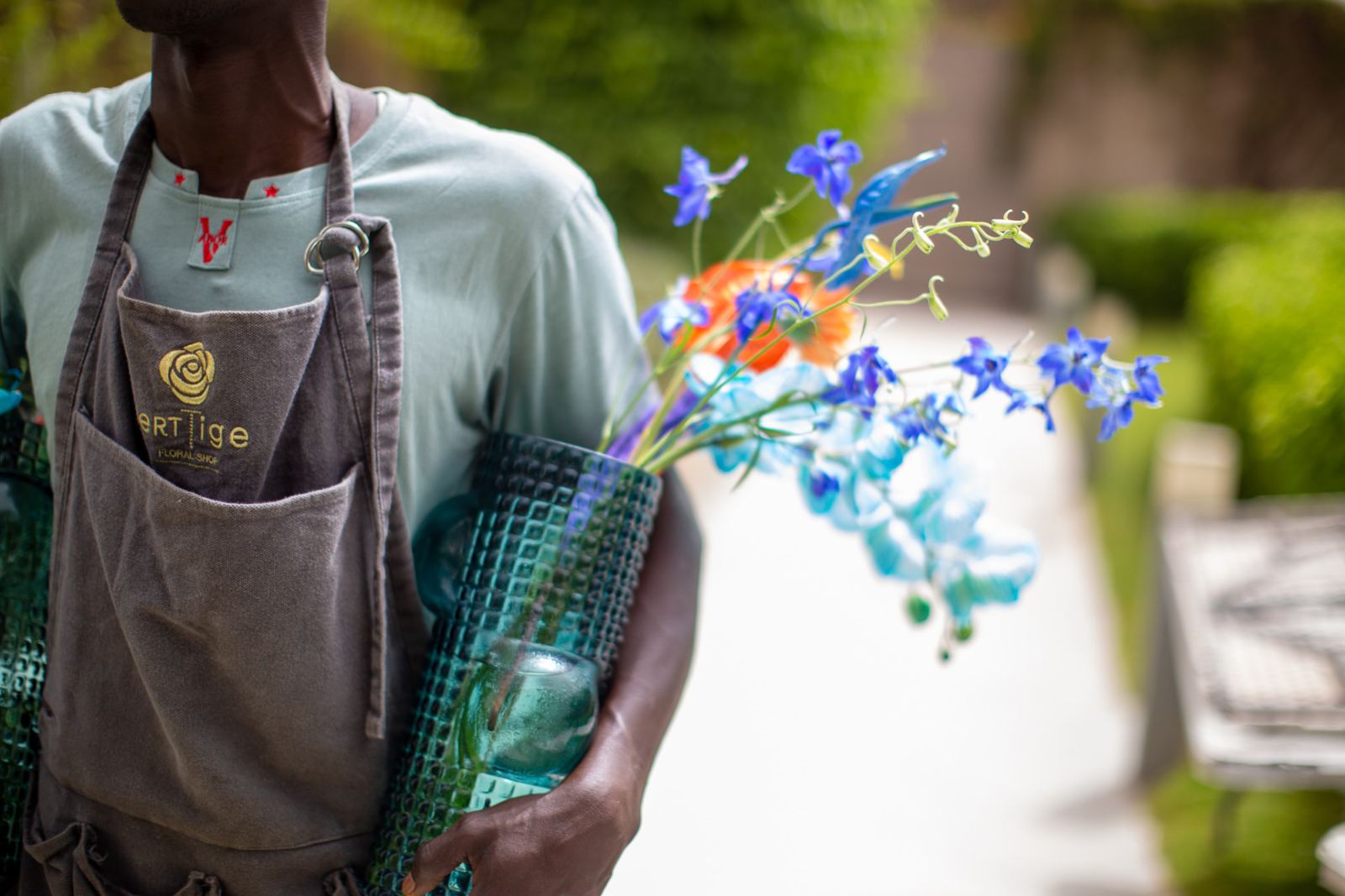 Fleuriste Verttige portant vases et fleurs