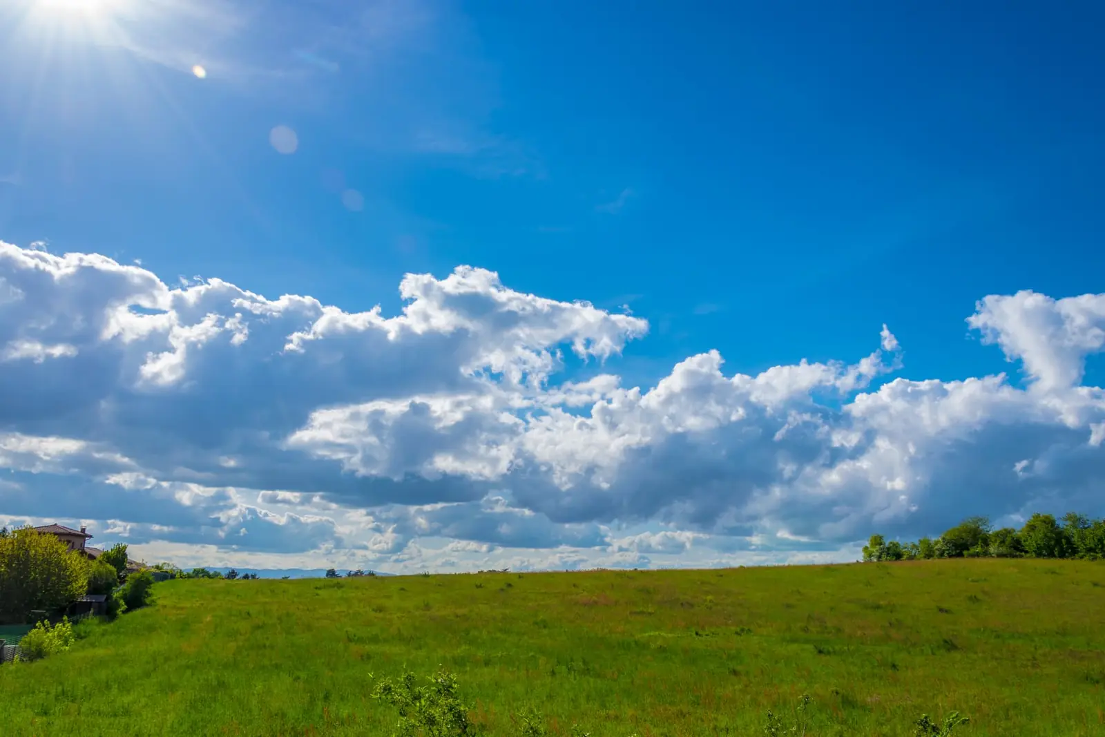 Prairie verte sous un ciel bleu et nuageux en région lyonnaise