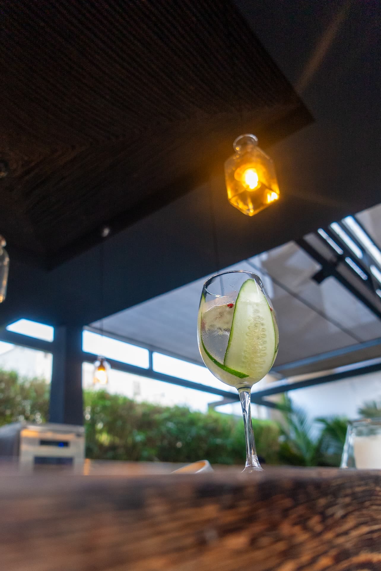 Cocktail au concombre sous une lampe du bar