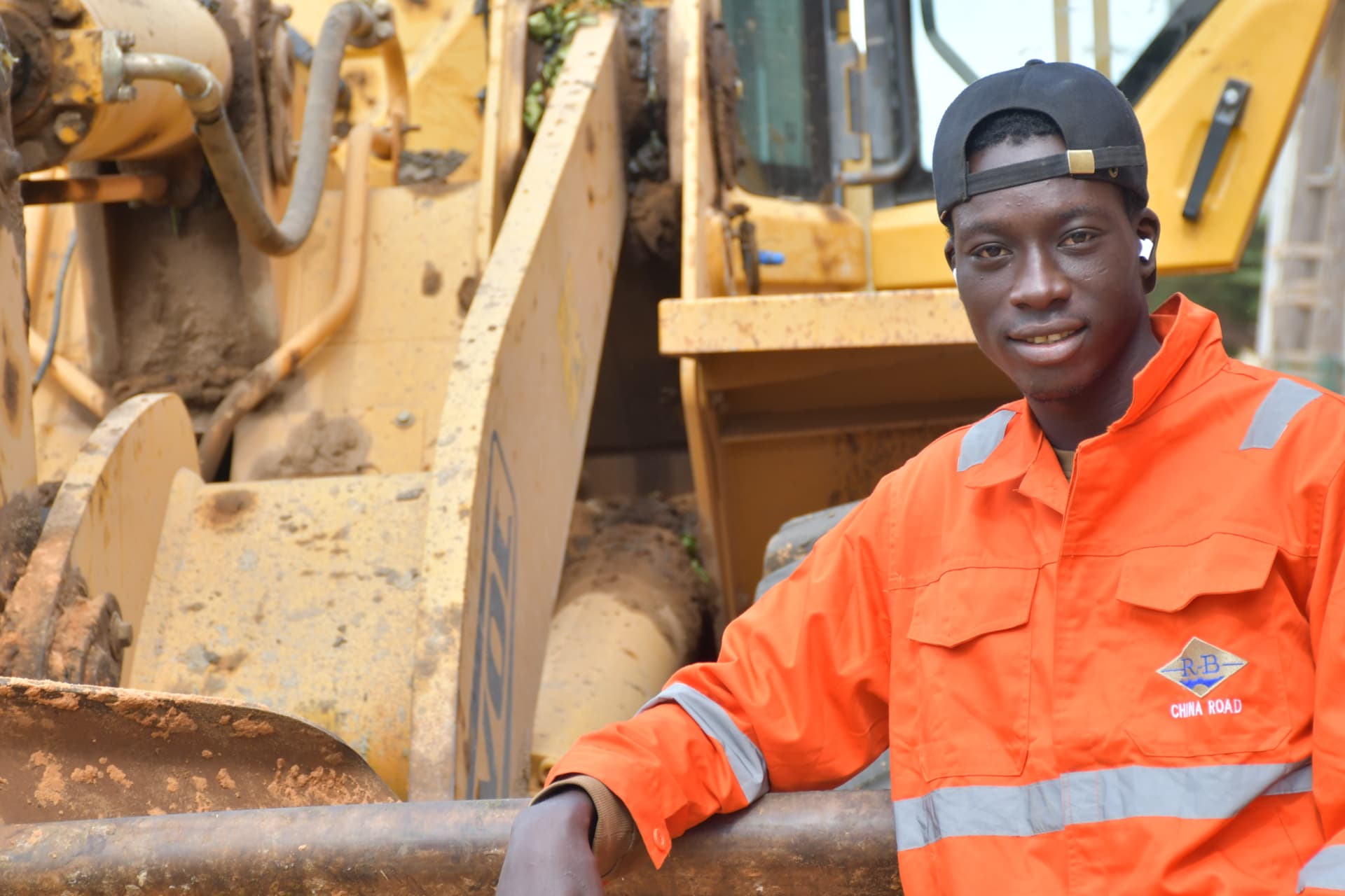 Portrait d'un ouvrier du chantier devant un engin