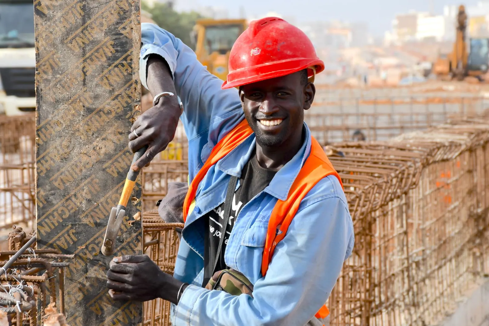 Ouvrier souriant près des armatures métalliques du chantier